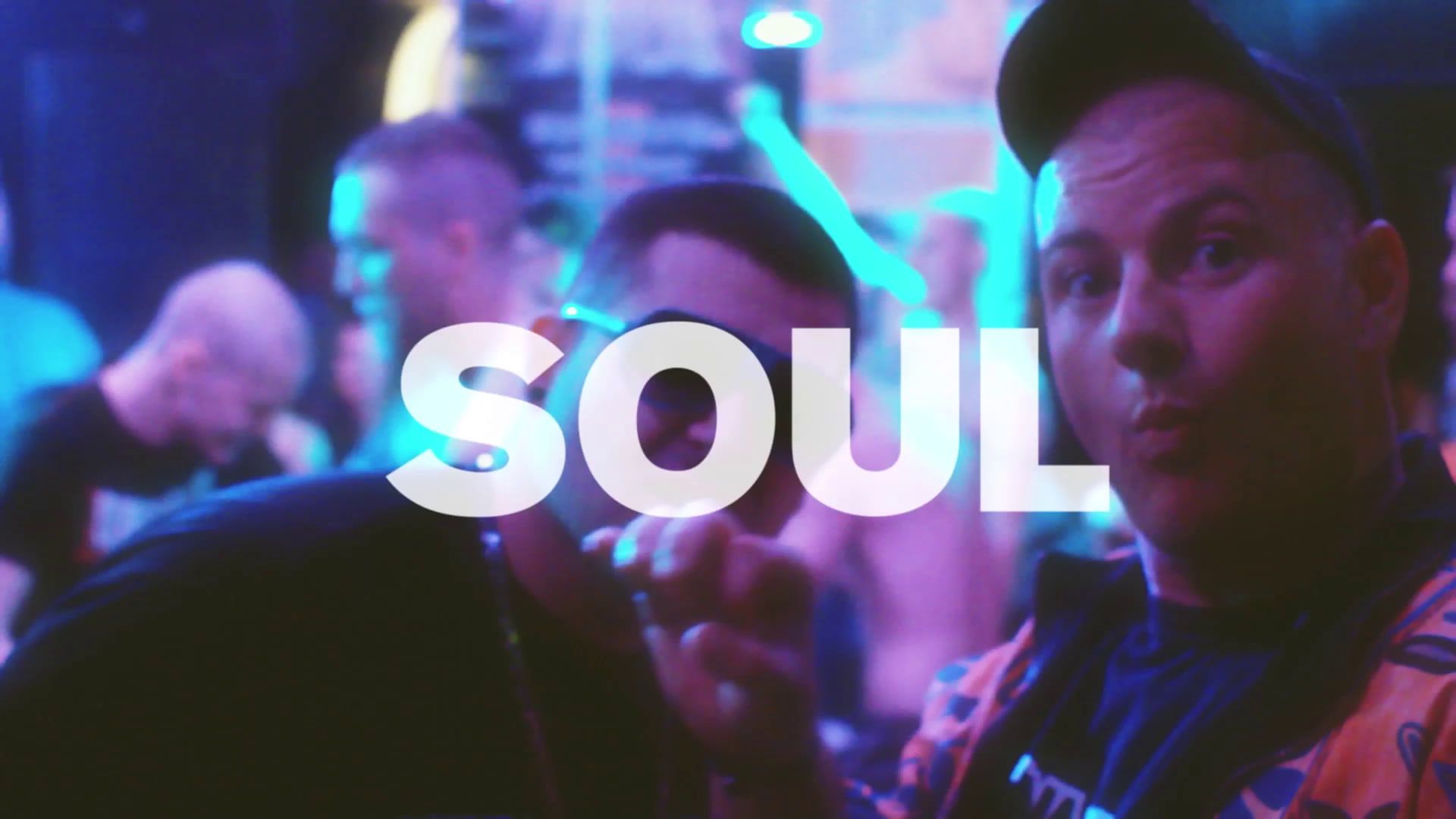 A man in a cap points towards the camera on a blue-lit dance floor, the word SOUL across the frame.
